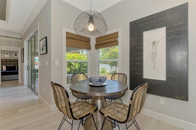 dining area featuring crown molding, light wood-type flooring, and baseboards