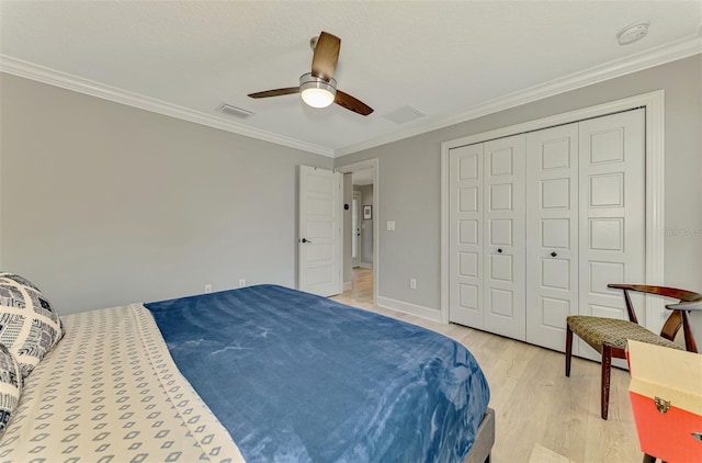 bedroom featuring light wood finished floors, crown molding, a ceiling fan, and a closet