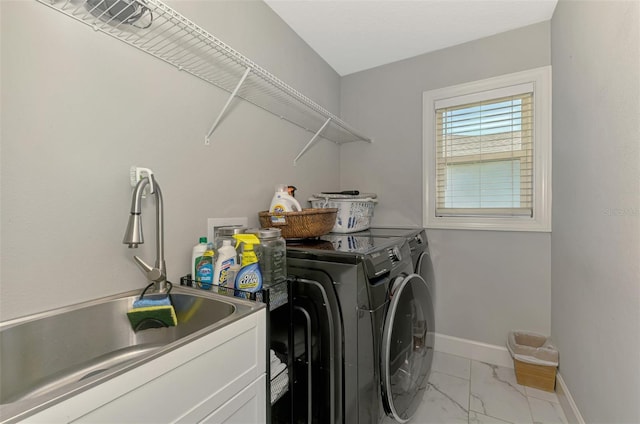 washroom with separate washer and dryer, light marble finish floors, and baseboards