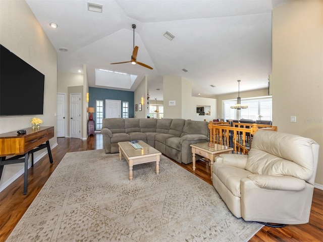 living room featuring a ceiling fan, lofted ceiling, visible vents, and wood finished floors