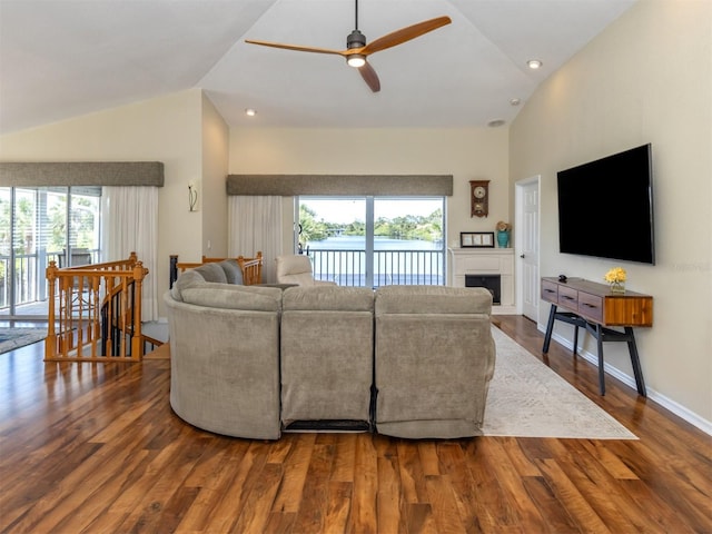 living area featuring a fireplace, a ceiling fan, high vaulted ceiling, and wood finished floors