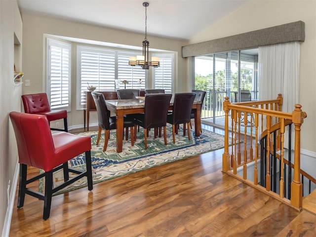 dining room with baseboards, a chandelier, wood finished floors, and lofted ceiling