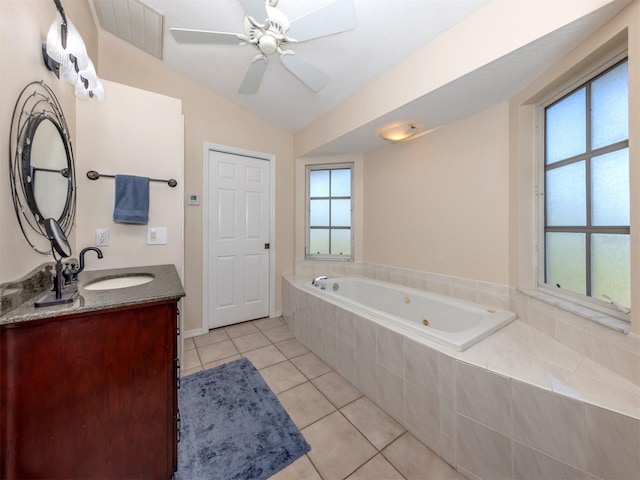 bathroom featuring a ceiling fan, a wealth of natural light, tile patterned flooring, and a tub with jets