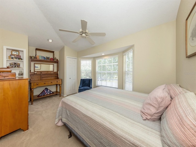 bedroom featuring light colored carpet, a closet, vaulted ceiling, and a ceiling fan