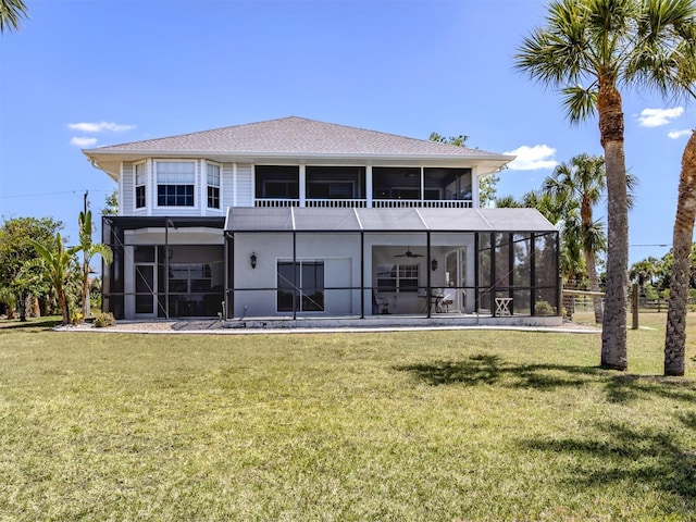 rear view of house featuring a lawn, a sunroom, and ceiling fan