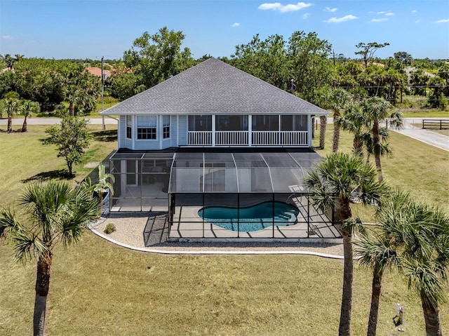 back of house featuring a hot tub, roof with shingles, an outdoor pool, a patio, and a lawn