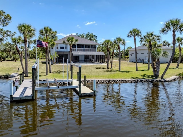 view of dock with boat lift, a water view, and a lawn