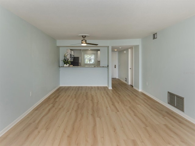 unfurnished living room with light wood-type flooring, ceiling fan, and baseboards