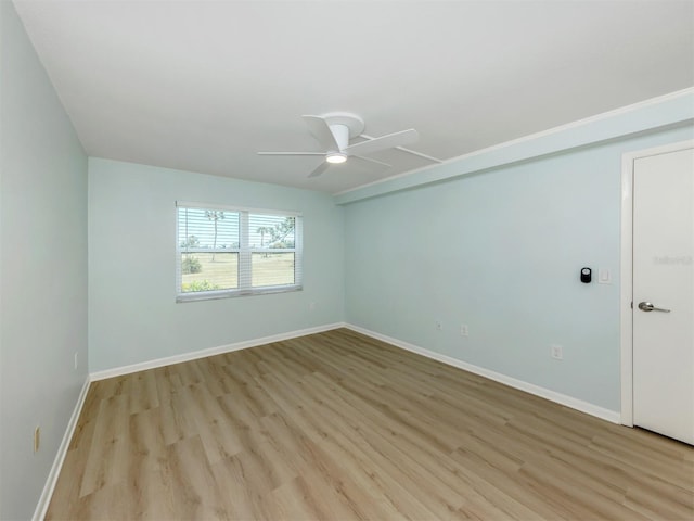 spare room featuring ceiling fan, light wood-style floors, and baseboards