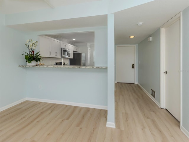 kitchen with stainless steel appliances, light wood-style flooring, baseboards, and recessed lighting