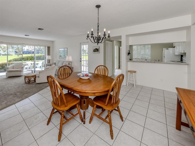 232 Cerromar Way Unit 38, Venice, FL 34293 - dining space with light tile patterned floors, a chandelier, and a textured ceiling