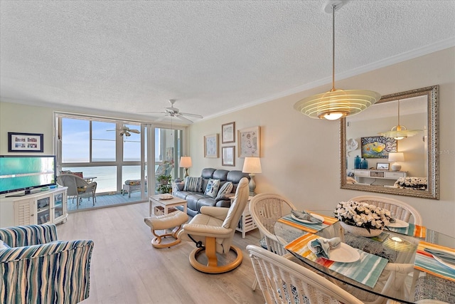 950 Tarpon Center Dr Unit 504, Venice, FL 34285 - living room featuring a textured ceiling, wood finished floors, crown molding, a ceiling fan, and a water view