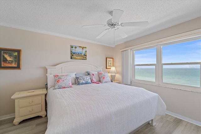 950 Tarpon Center Dr Unit 504, Venice, FL 34285 - bedroom featuring a textured ceiling, light wood-style floors, baseboards, ceiling fan, and crown molding
