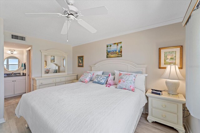 950 Tarpon Center Dr Unit 504, Venice, FL 34285 - bedroom featuring light wood-type flooring, ensuite bath, ornamental molding, a sink, and ceiling fan
