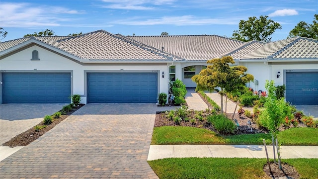 25069 Pearl Lake Cir, Englewood, FL 34223 - single story home featuring a tile roof, stucco siding, decorative driveway, and a garage