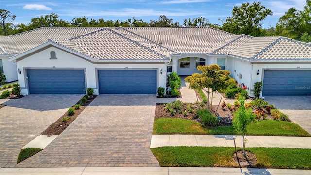 25069 Pearl Lake Cir, Englewood, FL 34223 - mediterranean / spanish house featuring stucco siding, a tile roof, driveway, and a garage