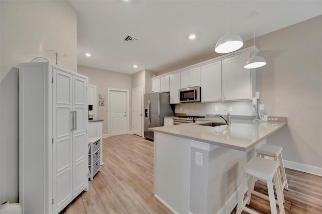 25069 Pearl Lake Cir, Englewood, FL 34223 - kitchen featuring stainless steel appliances, a sink, a breakfast bar, a peninsula, and baseboards
