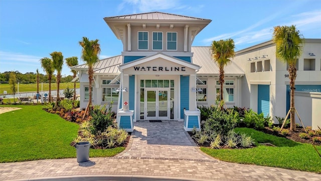 25069 Pearl Lake Cir, Englewood, FL 34223 - entrance to property featuring a standing seam roof, metal roof, a lawn, and stucco siding