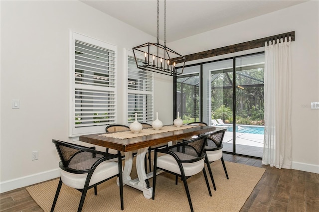 dining area with a chandelier, baseboards, and dark wood finished floors