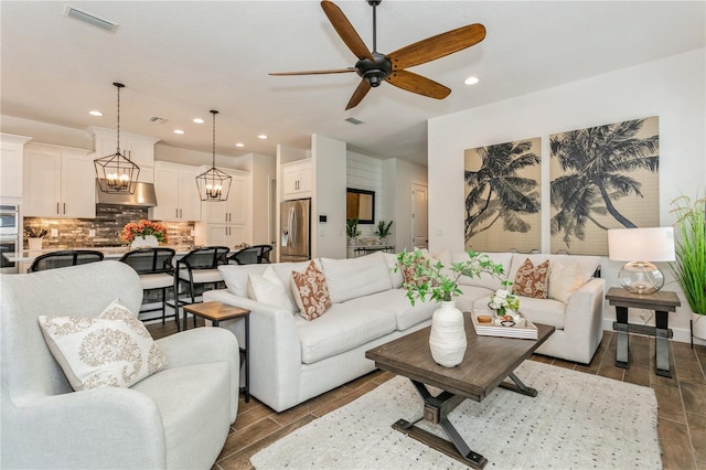living room with a ceiling fan, recessed lighting, and a chandelier