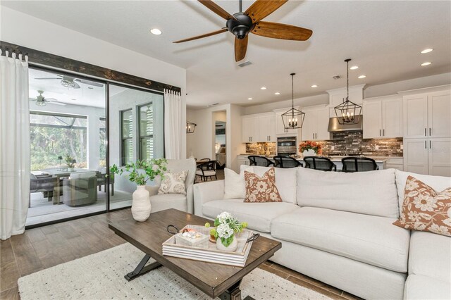 living room with ceiling fan, recessed lighting, and wood finished floors