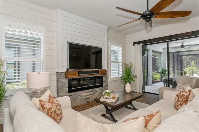 living room featuring a ceiling fan, wood finished floors, and a fireplace