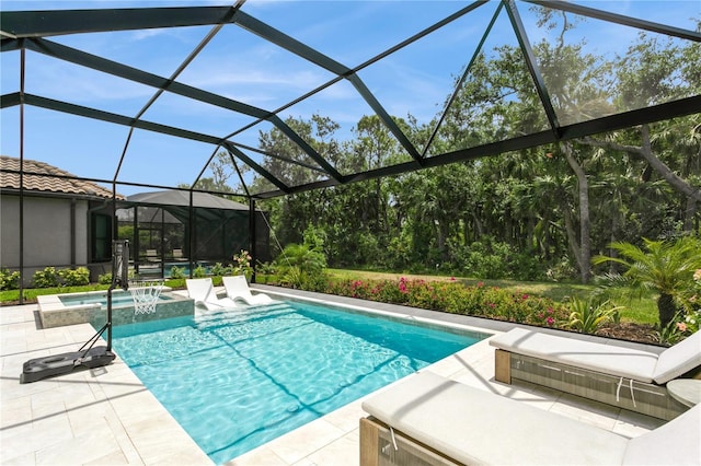 view of pool featuring a patio area, a pool with connected hot tub, and glass enclosure