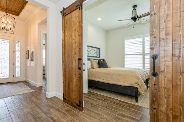 bedroom featuring dark wood finished floors, multiple windows, a barn door, baseboards, and recessed lighting