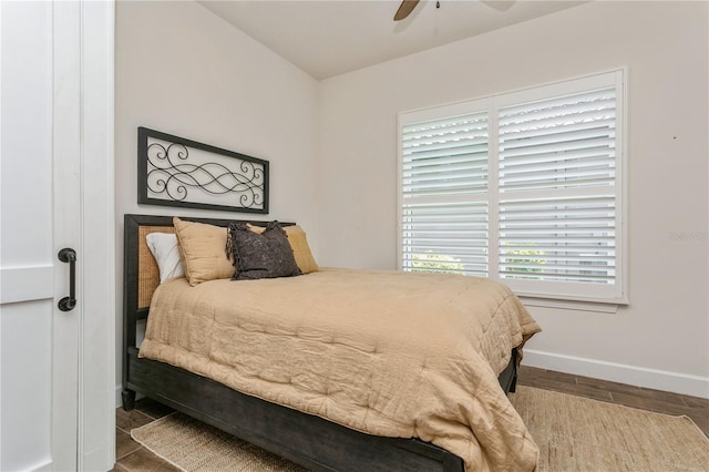 bedroom featuring baseboards, wood finished floors, and ceiling fan