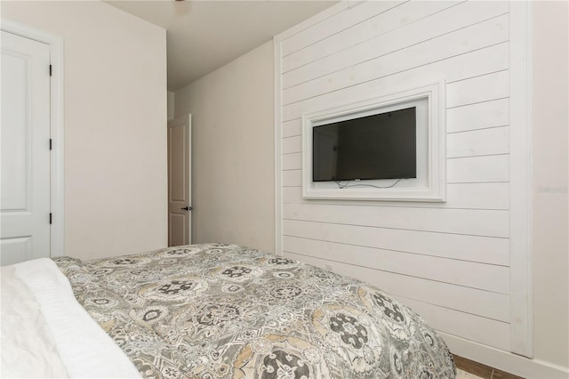 bedroom featuring wood walls