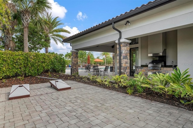 view of patio with area for grilling and a swimming pool