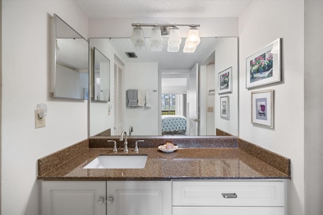 1156 Bird Bay Way Unit 104, Venice, FL 34285 - ensuite bathroom featuring vanity and a textured ceiling