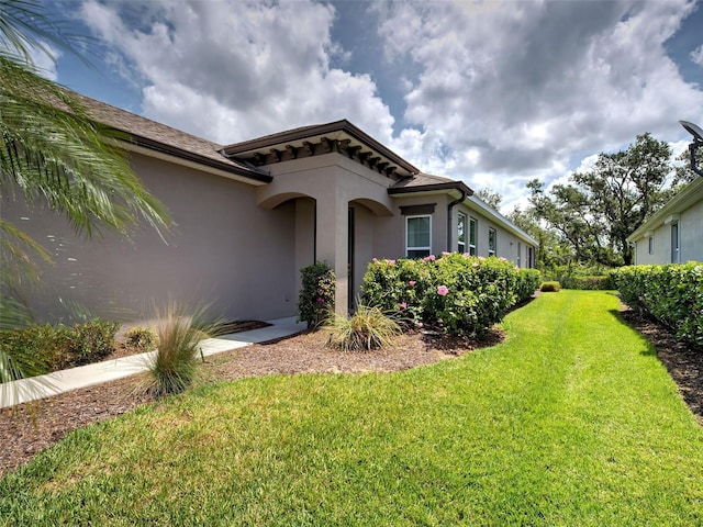 25784 Grayton Ave, Englewood, FL 34223 - view of front of home with stucco siding and a front lawn