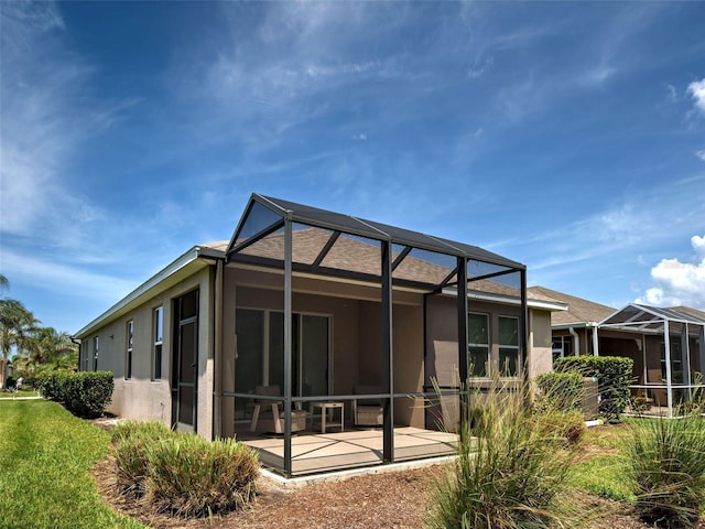 25784 Grayton Ave, Englewood, FL 34223 - rear view of property with stucco siding, a lanai, and a patio area