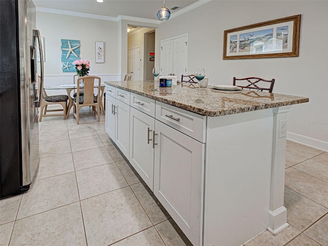 25784 Grayton Ave, Englewood, FL 34223 - kitchen featuring stainless steel fridge, ornamental molding, light tile patterned floors, white cabinetry, and light stone countertops