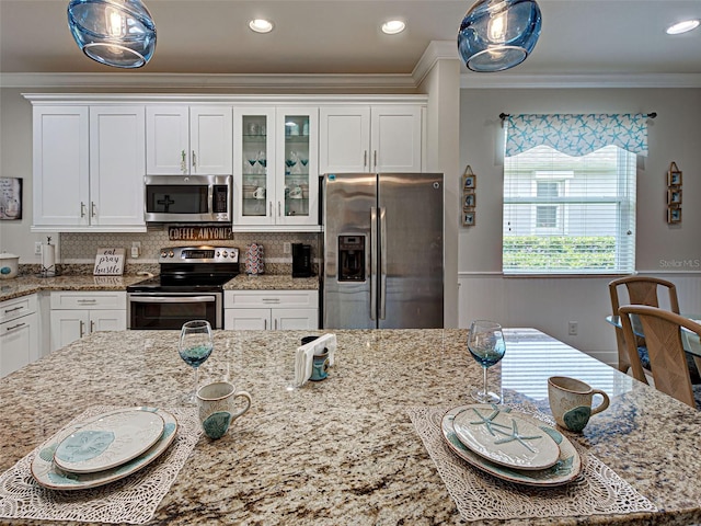 25784 Grayton Ave, Englewood, FL 34223 - kitchen with appliances with stainless steel finishes, white cabinetry, ornamental molding, glass insert cabinets, and wainscoting