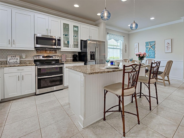 25784 Grayton Ave, Englewood, FL 34223 - kitchen featuring appliances with stainless steel finishes, crown molding, a center island, tasteful backsplash, and glass insert cabinets