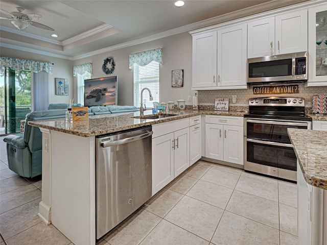 25784 Grayton Ave, Englewood, FL 34223 - kitchen featuring stainless steel appliances, open floor plan, crown molding, a peninsula, and tasteful backsplash