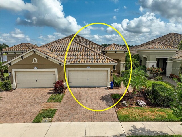 11648 Okaloosa Dr, Venice, FL 34293 - view of front of home featuring decorative driveway, stucco siding, an attached garage, and a tiled roof