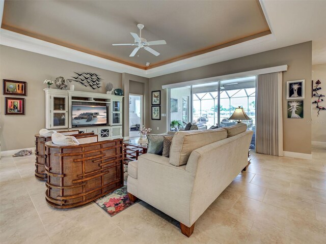 515 Sawgrass Bridge Rd, Venice, FL 34292 - living room featuring a tray ceiling, ceiling fan, baseboards, and light tile patterned floors
