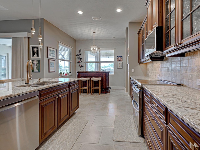 515 Sawgrass Bridge Rd, Venice, FL 34292 - kitchen with a sink, appliances with stainless steel finishes, pendant lighting, decorative backsplash, and baseboards