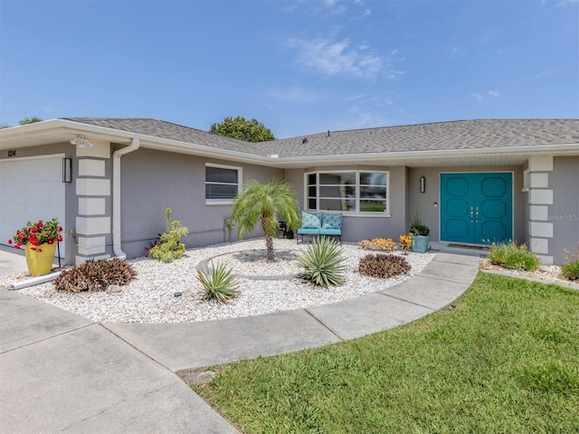 single story home featuring stucco siding, a garage, and roof with shingles