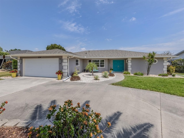 ranch-style home featuring stucco siding, concrete driveway, an attached garage, and a front yard