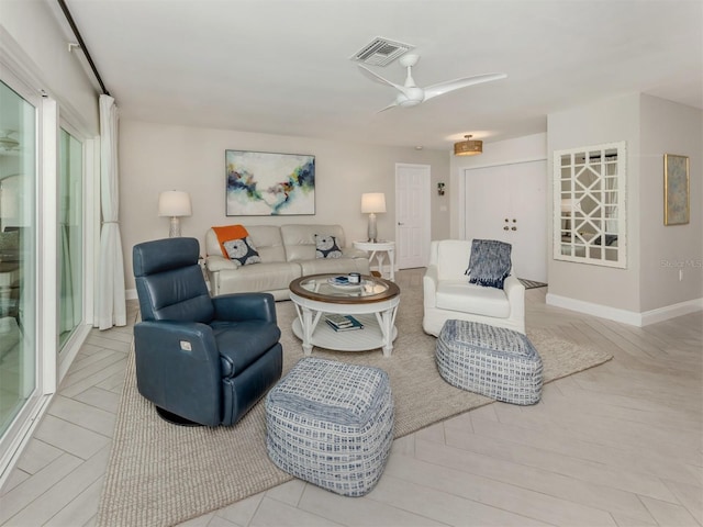 living room featuring a ceiling fan and baseboards