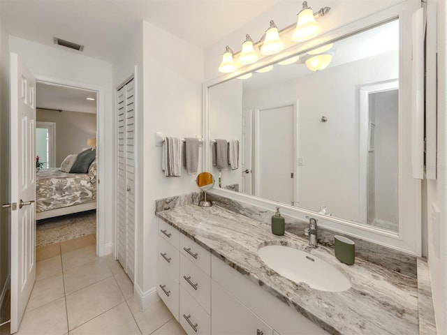 full bathroom featuring tile patterned floors, vanity, ensuite bathroom, and baseboards