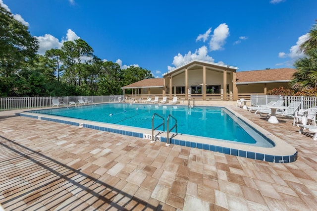 community pool with fence and a patio area
