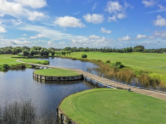 view of home's community with golf course view, a water view, and view of wooded area