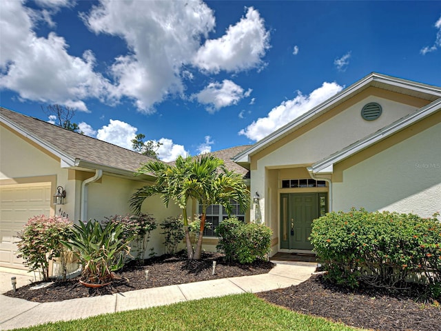 4103 Kinlock St, North Port, FL 34286 - property entrance featuring stucco siding, an attached garage, and a shingled roof