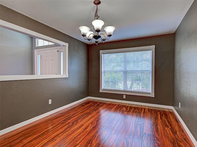 4103 Kinlock St, North Port, FL 34286 - spare room featuring a chandelier, a textured wall, wood finished floors, and a textured ceiling
