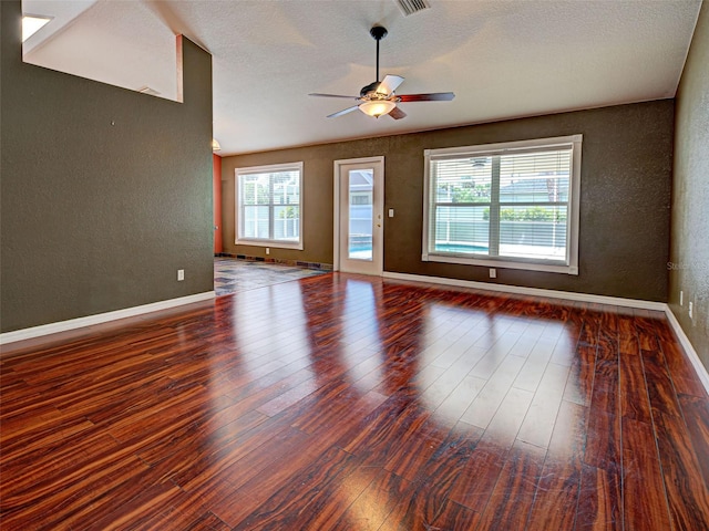 4103 Kinlock St, North Port, FL 34286 - unfurnished living room featuring a textured wall, wood finished floors, a ceiling fan, and a textured ceiling